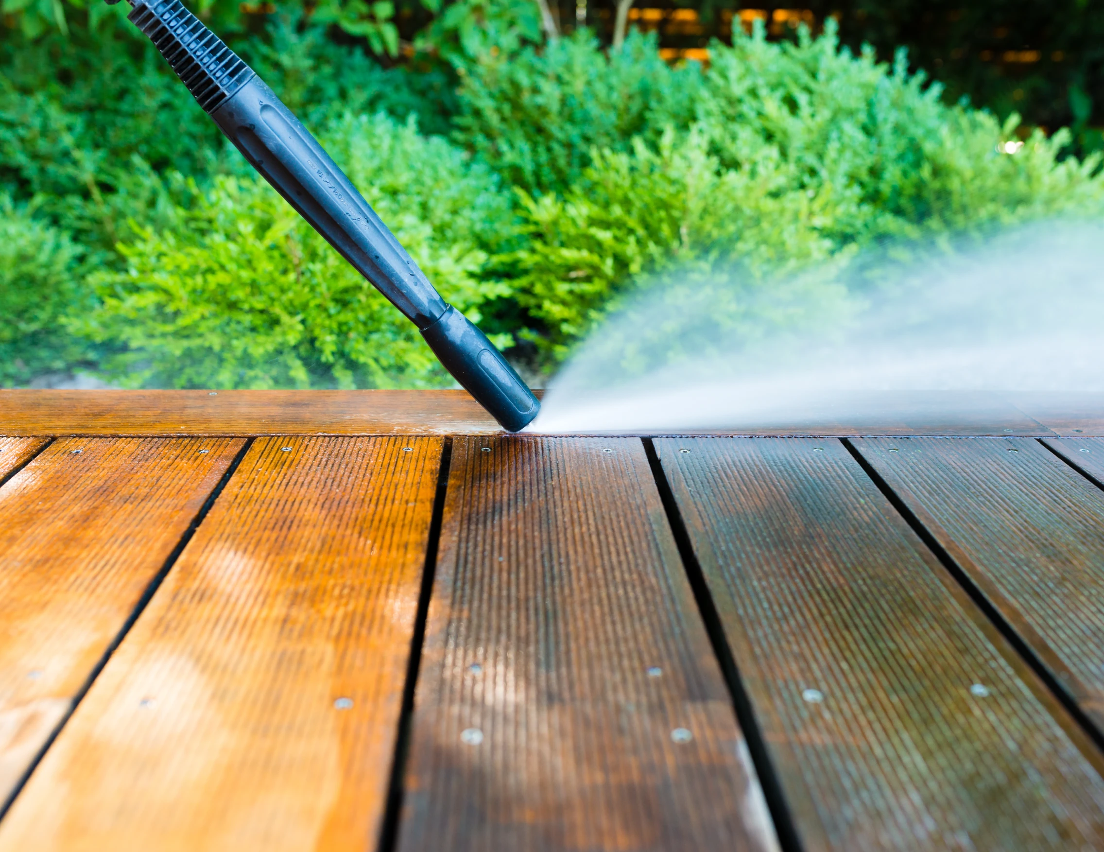 stock-photo-cleaning-terrace-with-a-power-washer-high-water-pressure-cleaner-on-wooden-terrace-surface-1887639460