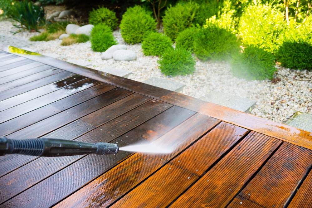 stock-photo-cleaning-terrace-with-a-power-washer-high-water-pressure-cleaner-on-wooden-terrace-surface-553183696